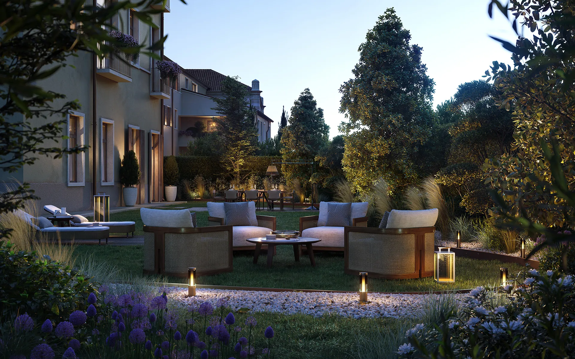Giardino elegante con luci soffuse, poltrone imbottite circolari attorno a un tavolino e piante verdi e fiori viola in un ambiente residenziale al tramonto.
