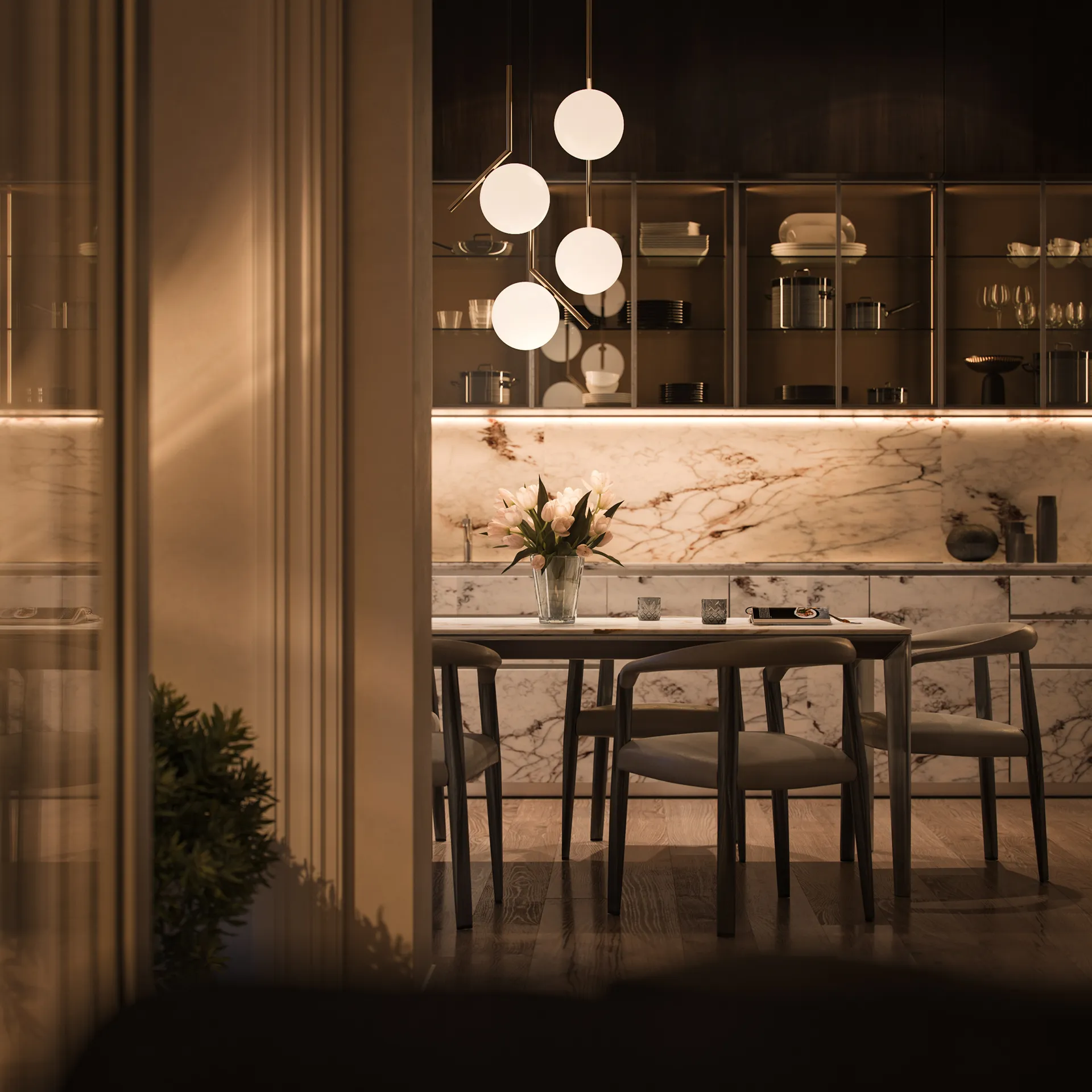 Cucina moderna con tavolo in marmo, quattro sedie, vaso con fiori bianchi e lampadario a sfere luminose.