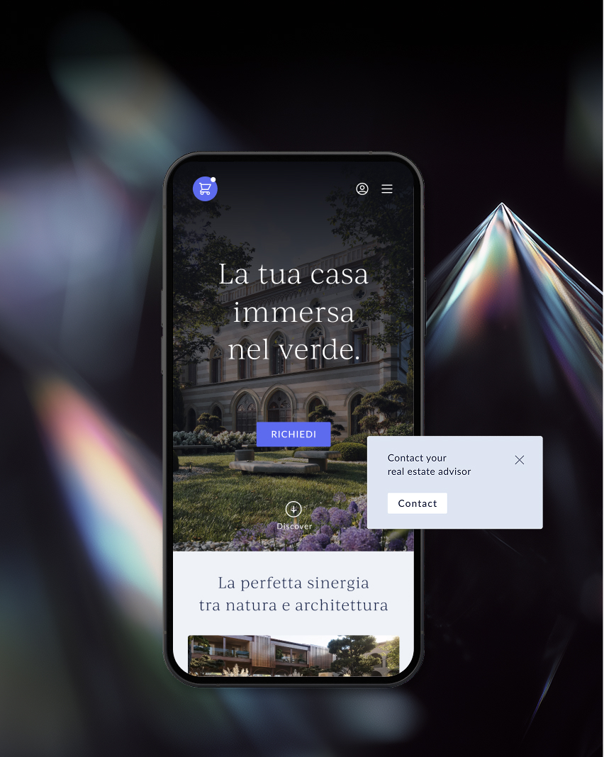 Smartphone screen displaying an Italian real estate app with text about a house immersed in greenery and a button to contact a real estate advisor.