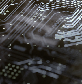 Close-up of a black circuit board with silver electronic traces and connection points.